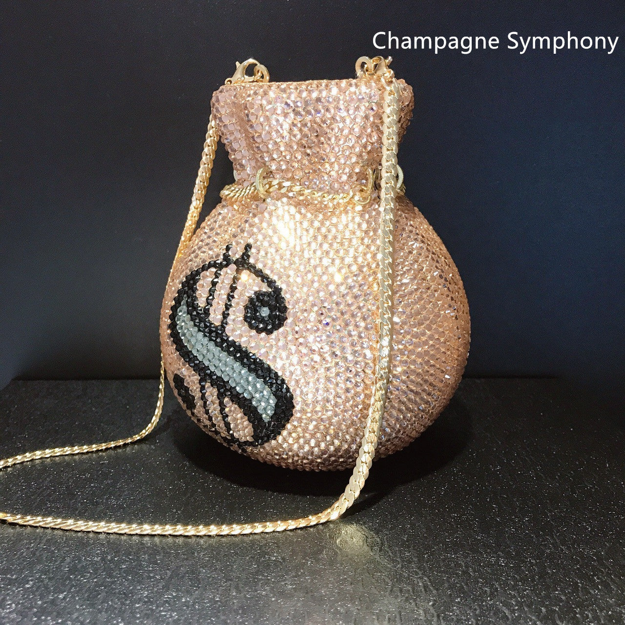 Sparkly handbag with a logo on a dark surface and background