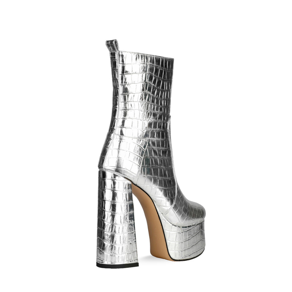 Silver platform boot with high heel on a white background