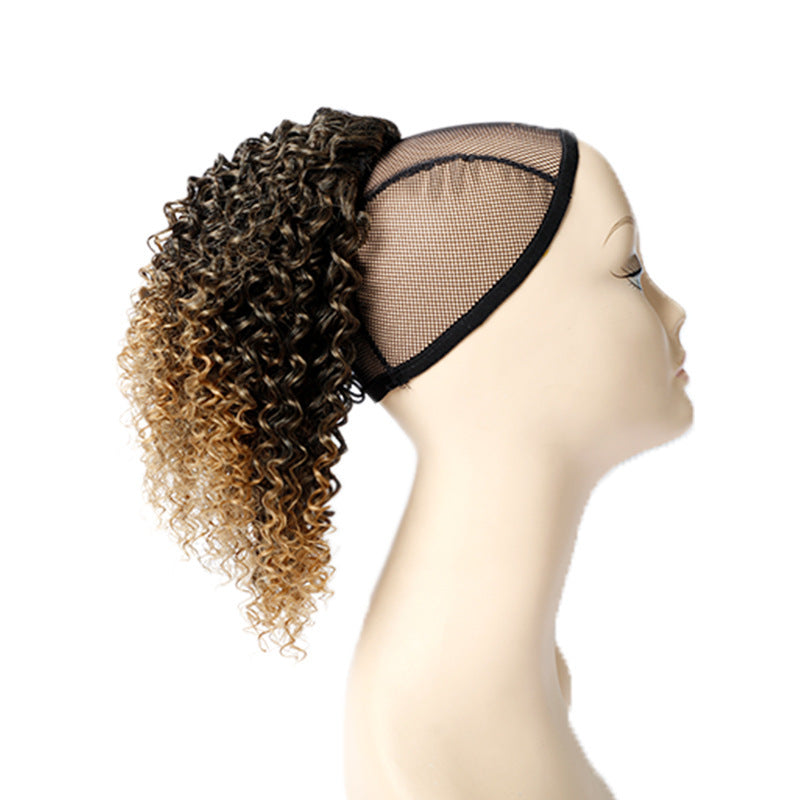 Mannequin head with a curly hairpiece featuring brown and blonde color gradient on a white background.