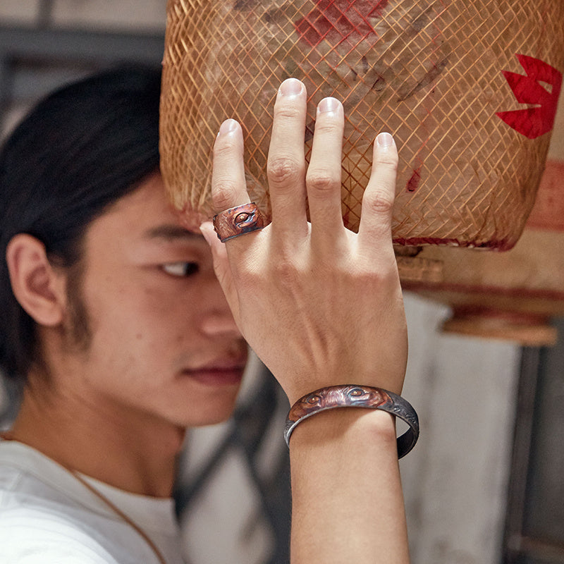 Person wearing a ring and bracelet with a blurred background