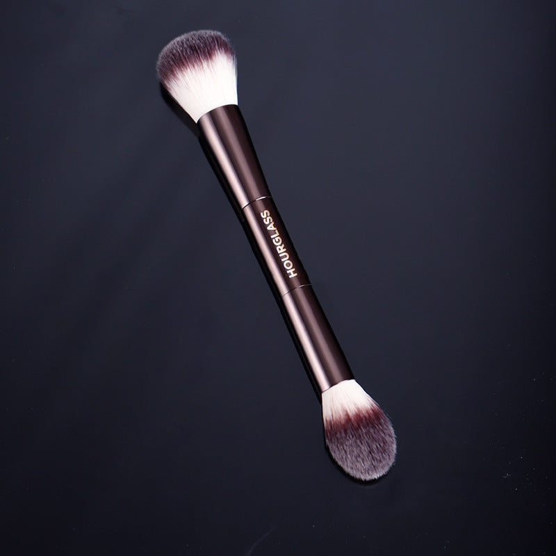 Makeup brush with 'KVD' branding on a black background