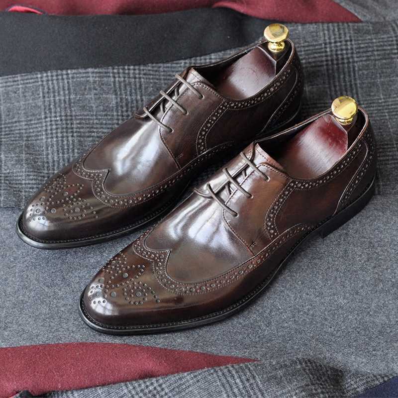 Pair of brown leather dress shoes on a textured fabric surface