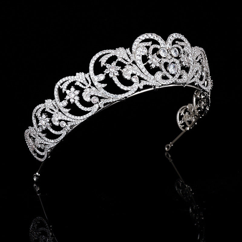 Silver tiara with intricate design on a black background