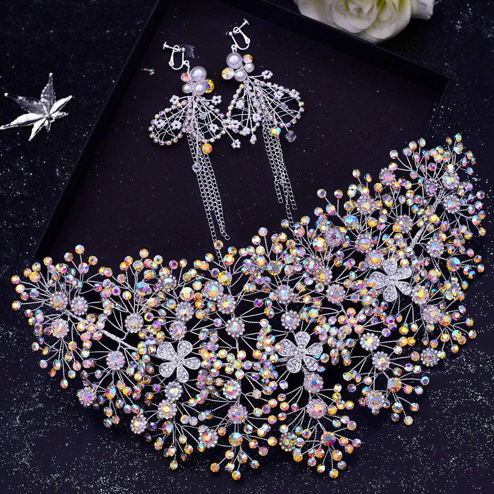 Decorative necklace and earrings on a dark surface with a white flower in the corner.