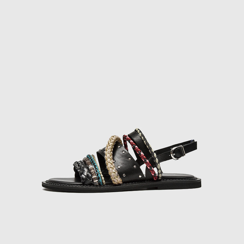 Black sandal with multicolored straps on a light gray background