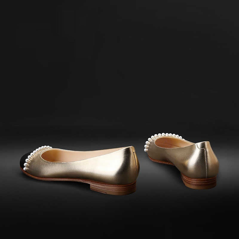 Gold shoes with pearl accents on a black background