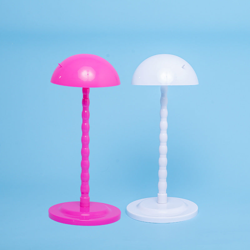 Two colorful lampshades, one pink and one white, on a blue background.