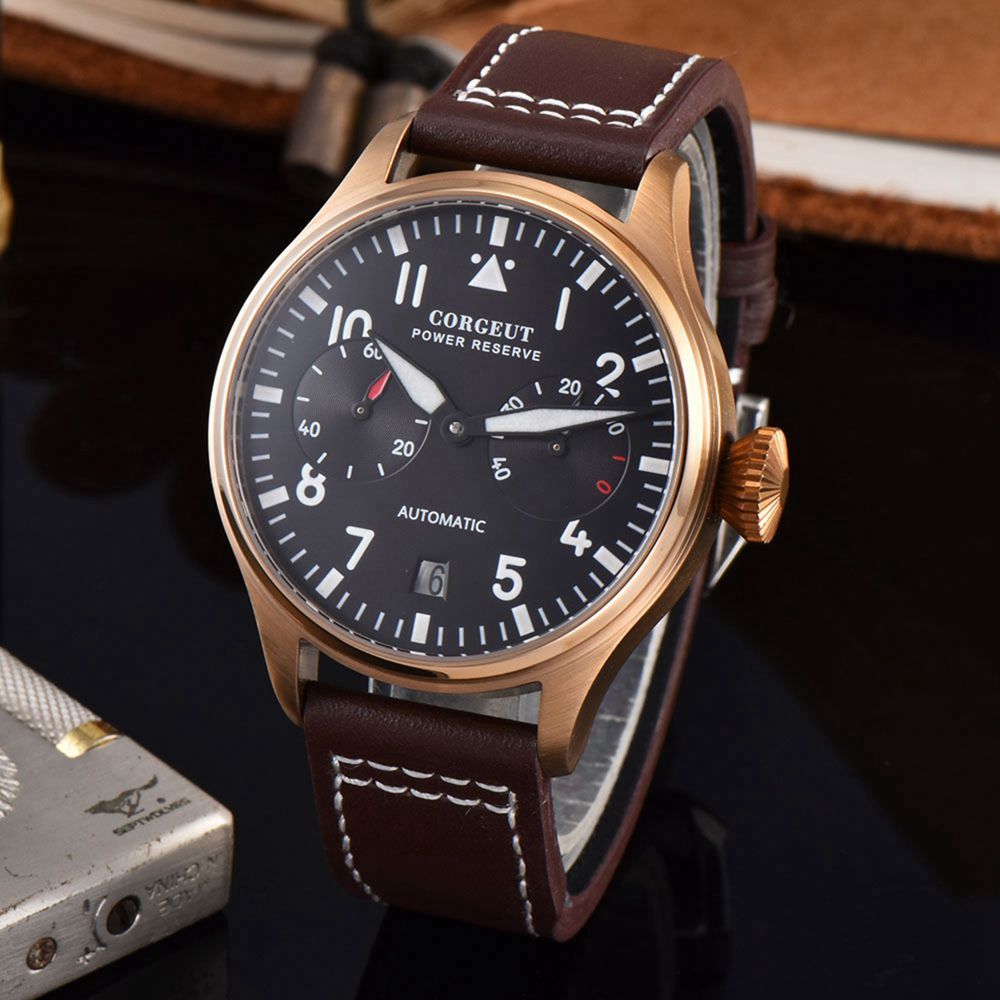 Watch with brown leather strap and black dial on a dark surface