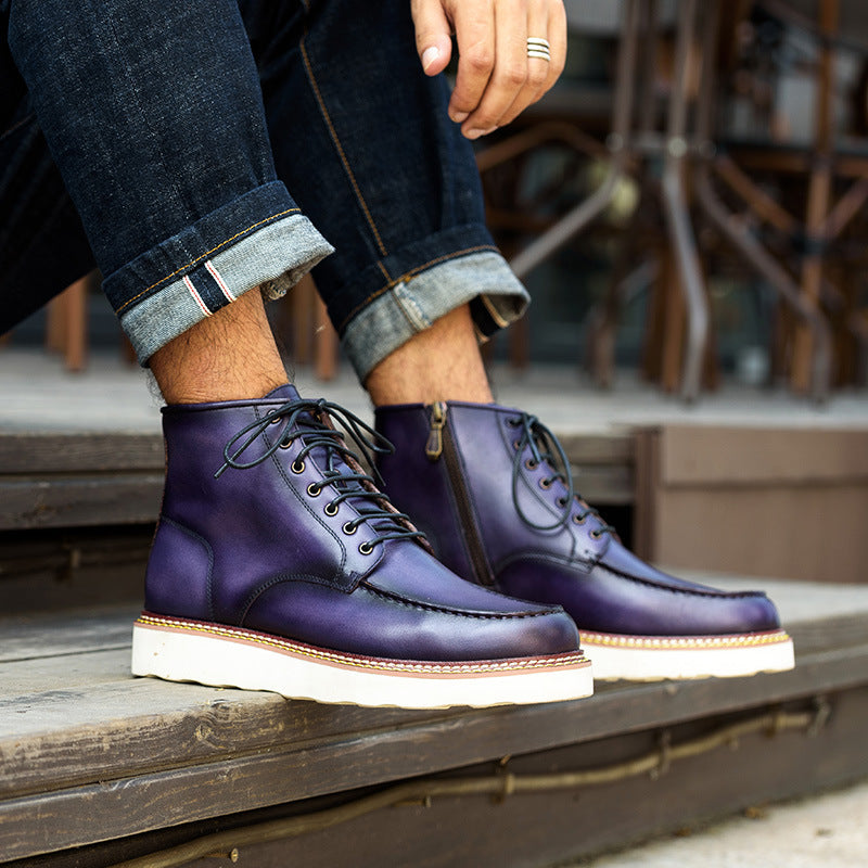Purple boots with white soles worn by a person sitting on a wooden bench.