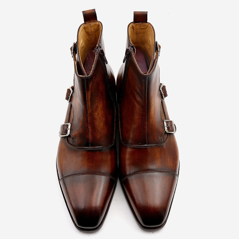 Pair of brown leather boots with buckles on a white background
