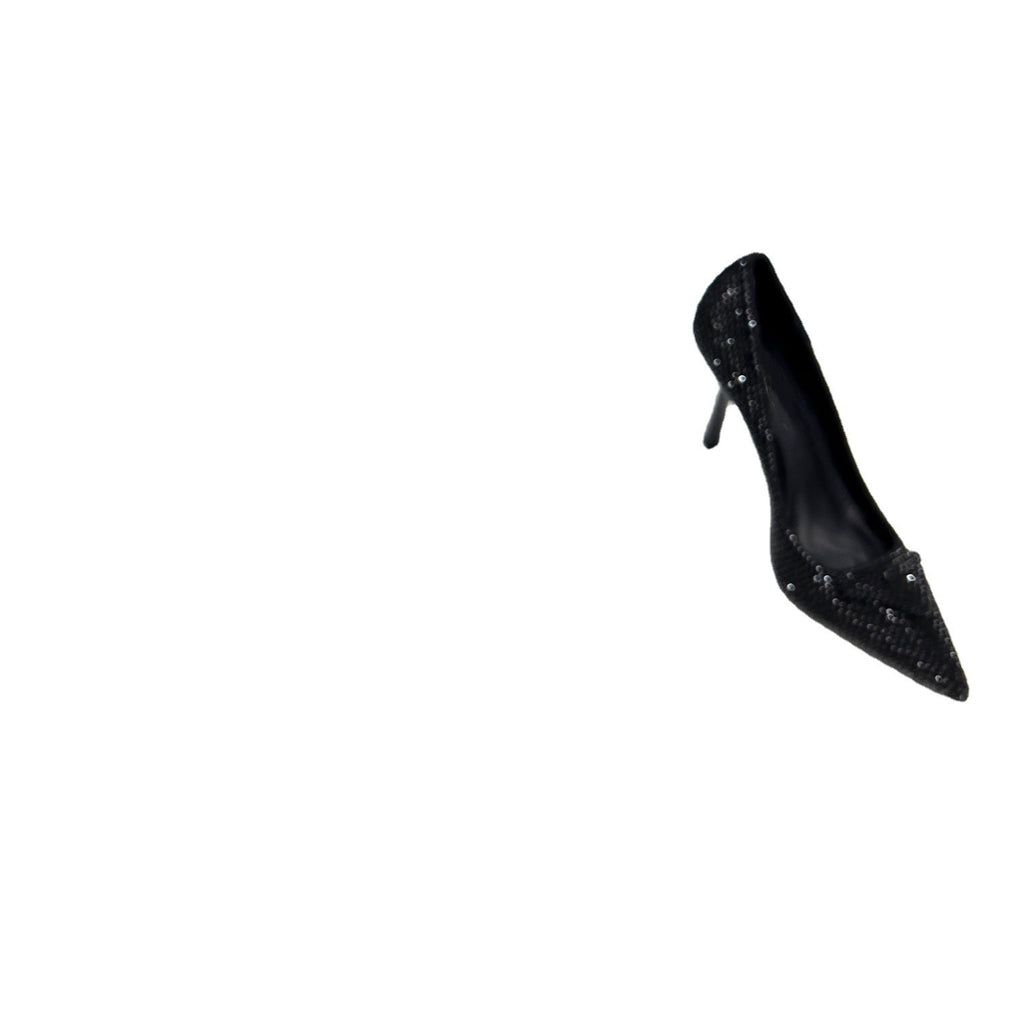 Black high-heeled shoe with studded detail on a white background