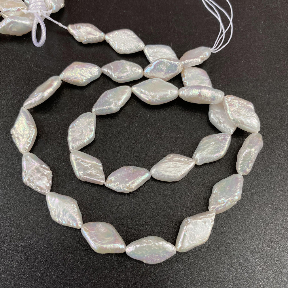 String of irregularly shaped pearl beads on a dark surface