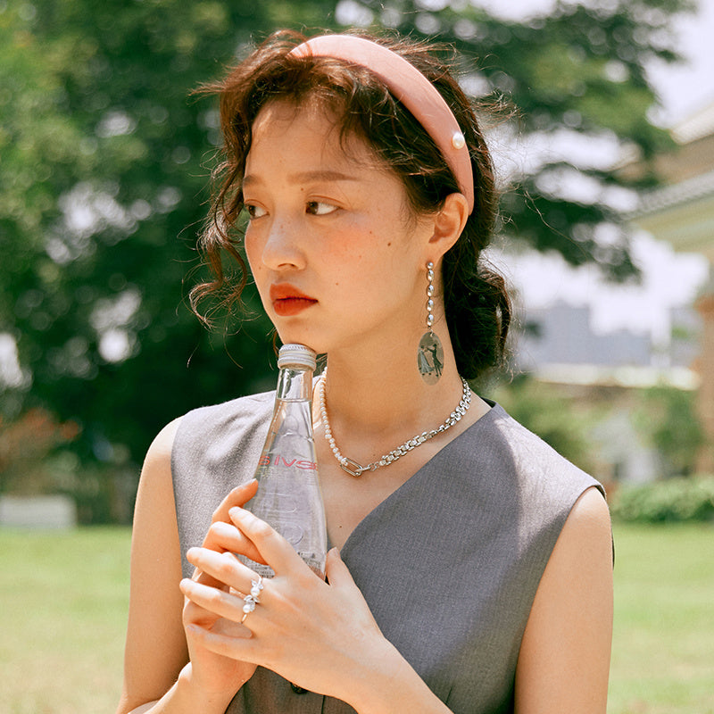Woman holding a bottle outdoors with a blurred natural background