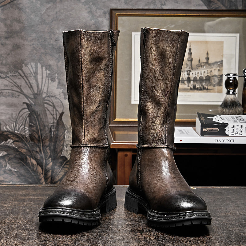 Pair of brown leather boots on a textured surface with a decorative background.