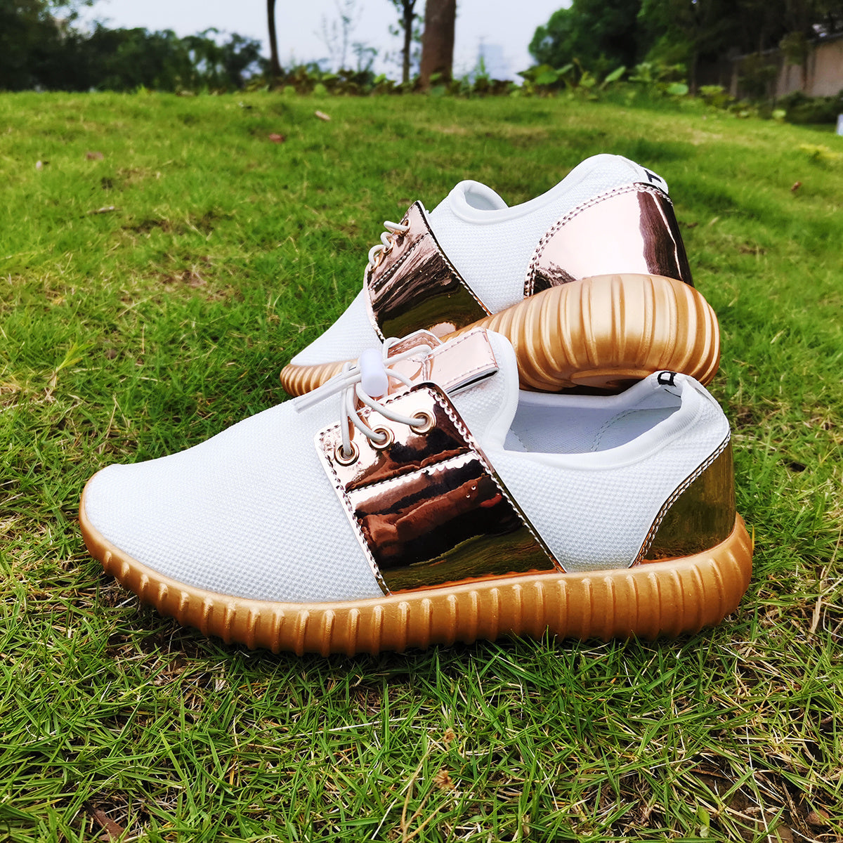 White sneakers with gold accents on a grassy background