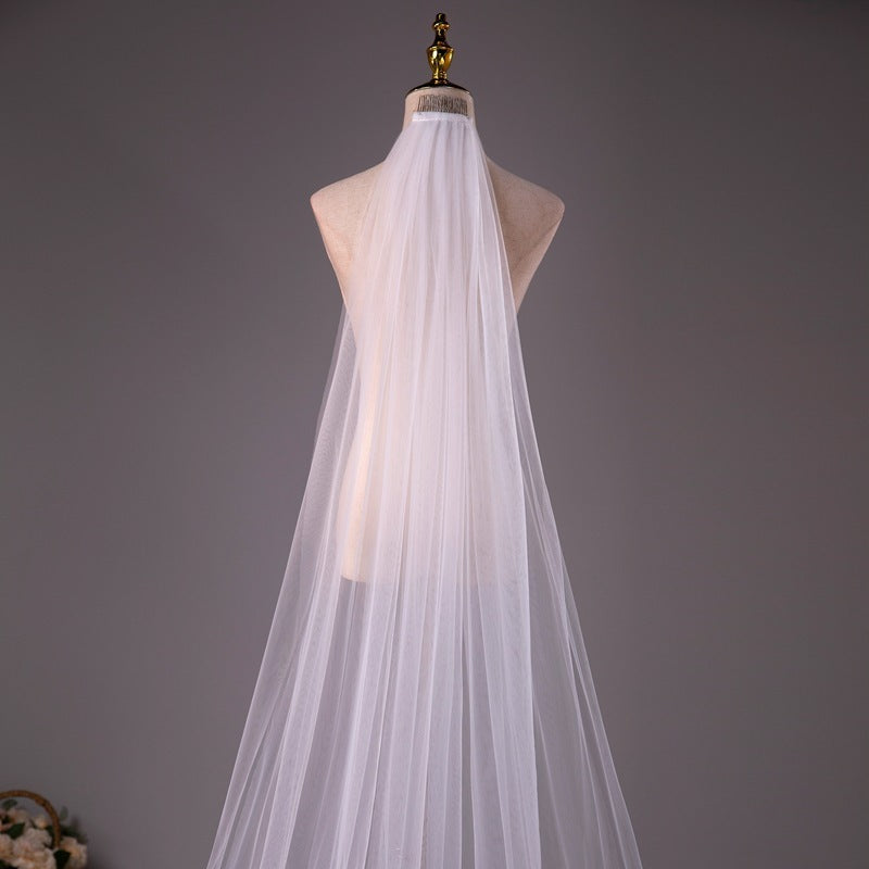 White wedding veil on a mannequin against a gray background