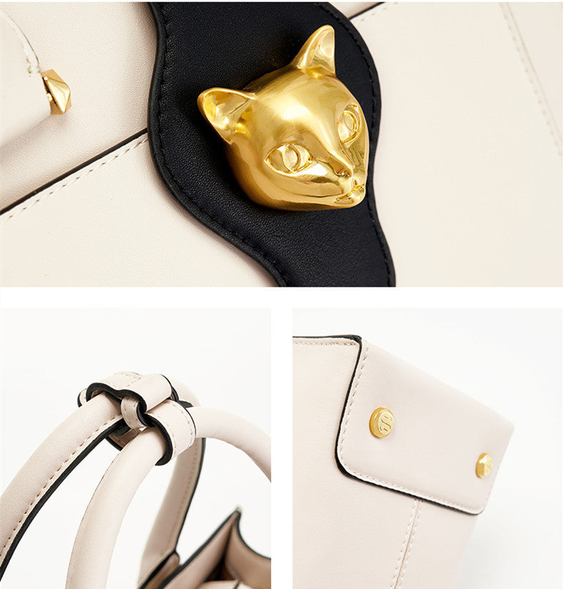 White handbag with gold cat-shaped handle and decorative button on a white background