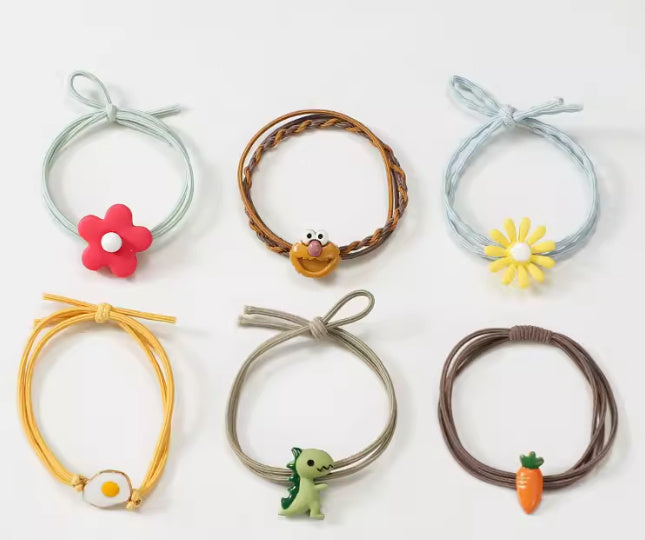 Set of colorful hair ties with decorative ends on a white background
