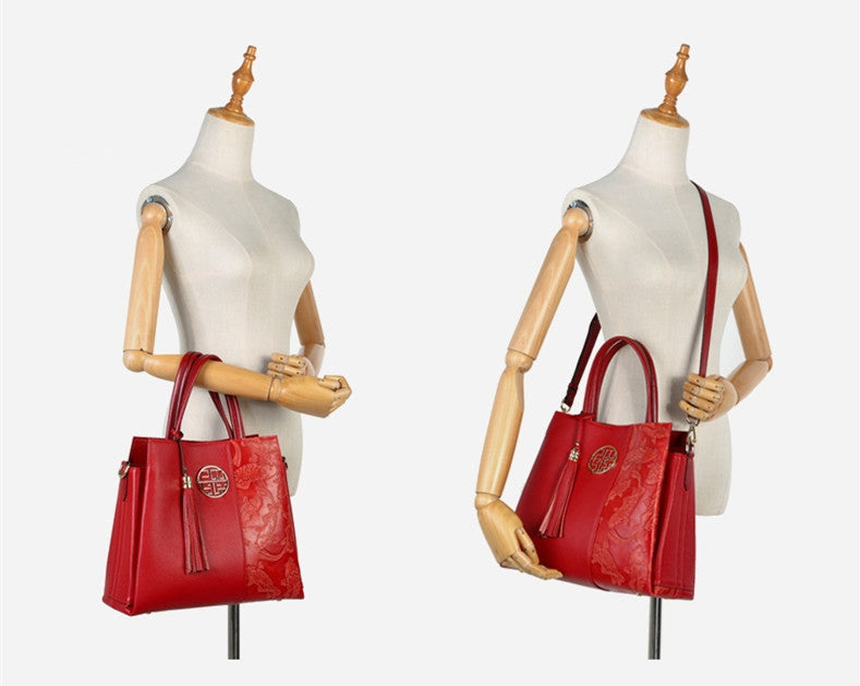 Two red handbags on mannequins against a white background