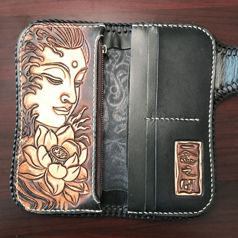 Black leather wallet with embossed face and floral design on a wooden surface