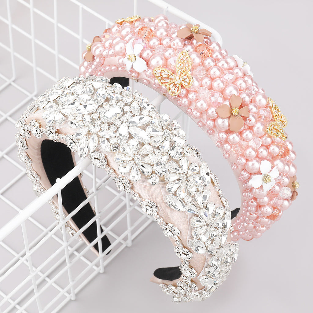 Two decorative headbands, one pink with pearls and flowers, the other silver with crystals, on a white grid background.
