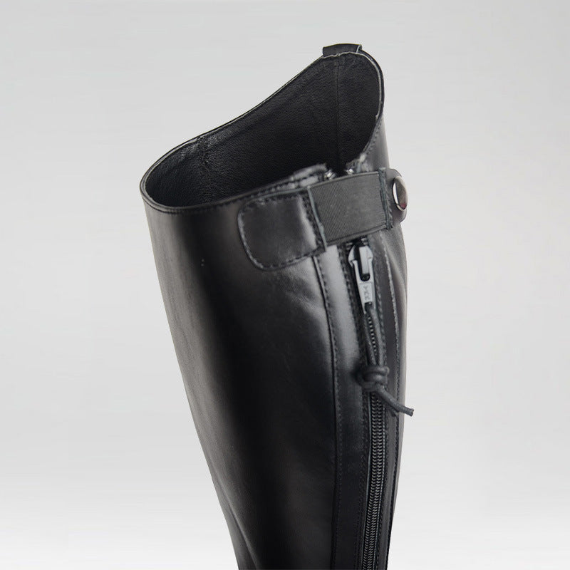 Black leather boot with a zipper on a light gray background
