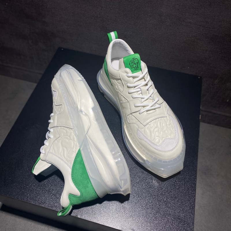 White sneakers with green accents on a dark surface