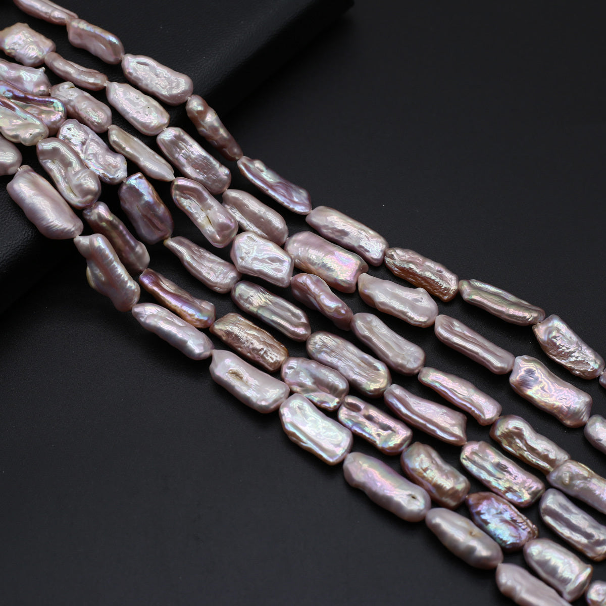 Strand of irregularly shaped pearls on a dark background