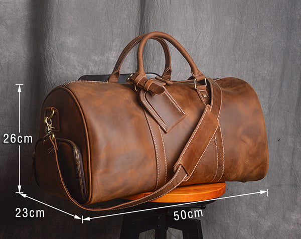 Brown leather duffel bag with measurements on a gray background