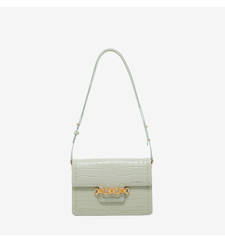 Light green handbag with gold clasp on a white background