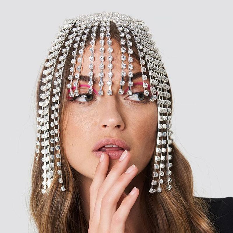 Woman wearing a headpiece with crystals on a plain background