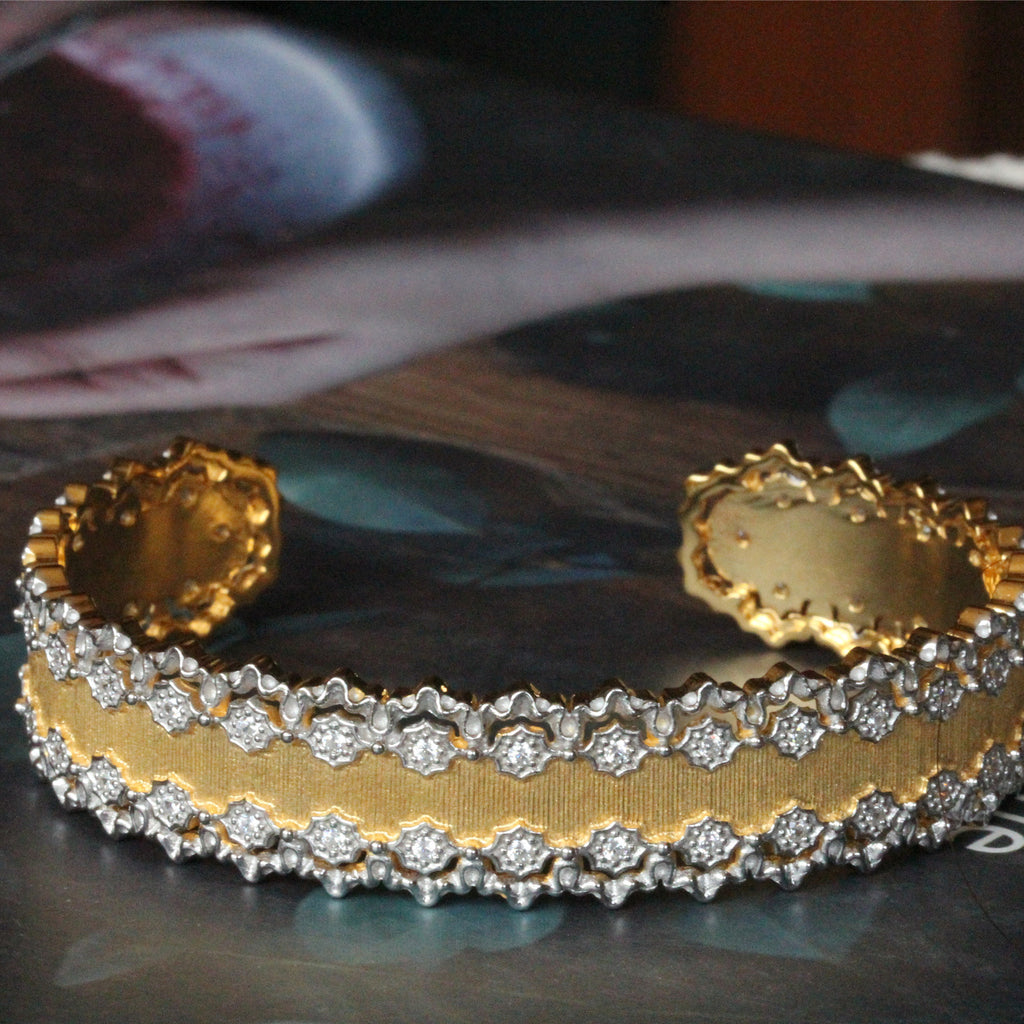 Gold bracelet with diamond accents on a reflective surface