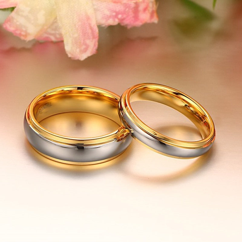 Two gold rings on a soft pink background with flowers.