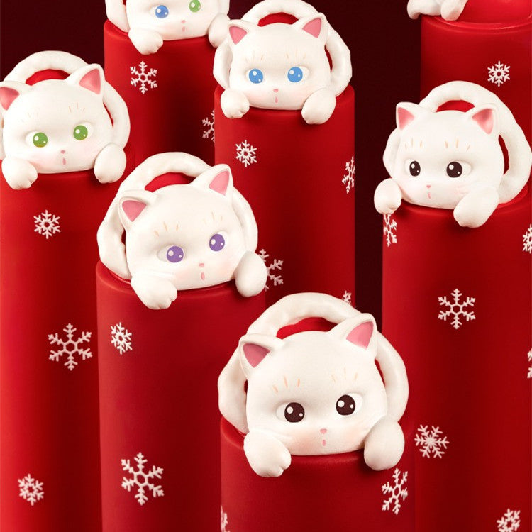 Red cylindrical containers with white cat-shaped handles on a red background with snowflakes.