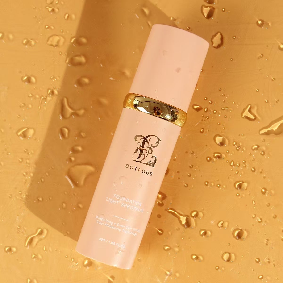 Skincare bottle with gold cap on a golden background with water droplets