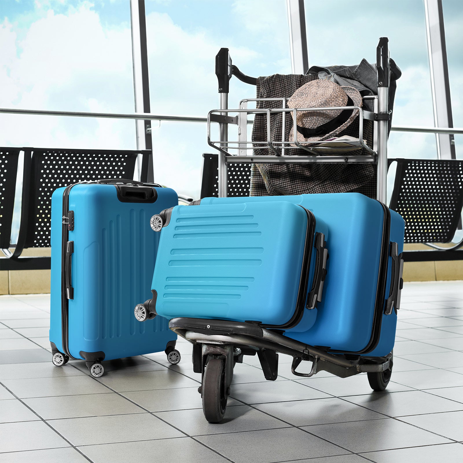 Two blue suitcases with a black trolley in an airport setting