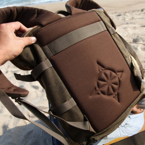 Brown bag with a star design held by a hand on a beach.