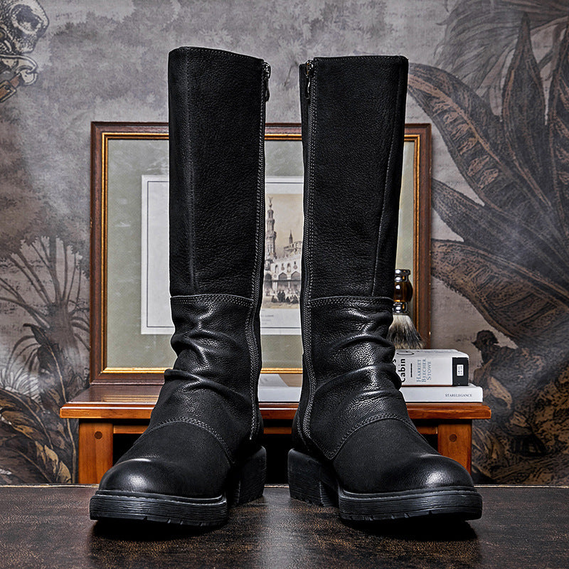 Pair of black leather boots on a textured surface with a decorative background
