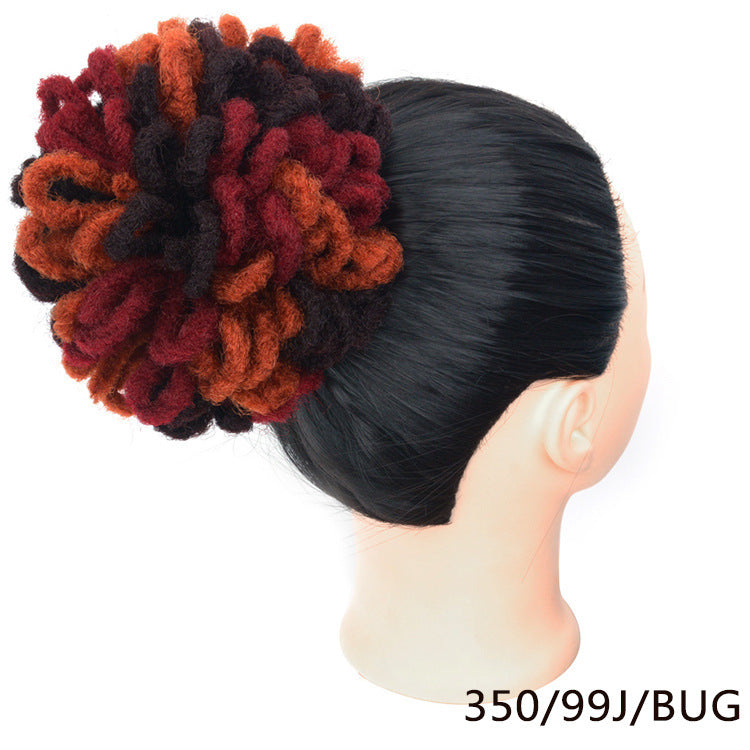 Mannequin head with a colorful hair bun accessory on a white background