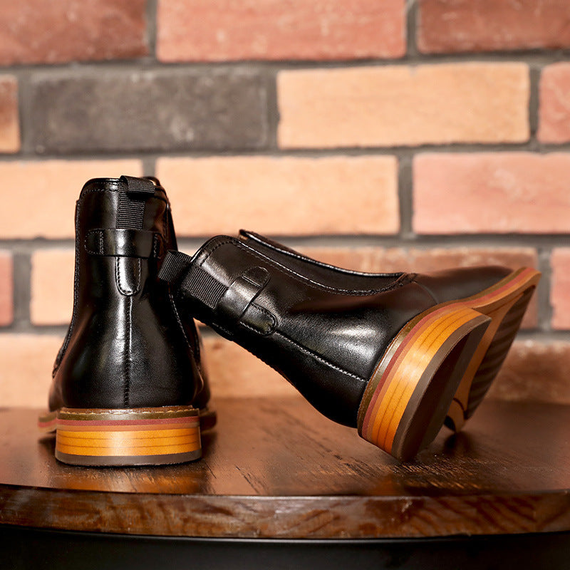 Black leather shoes with wooden soles on a wooden surface against a brick wall.