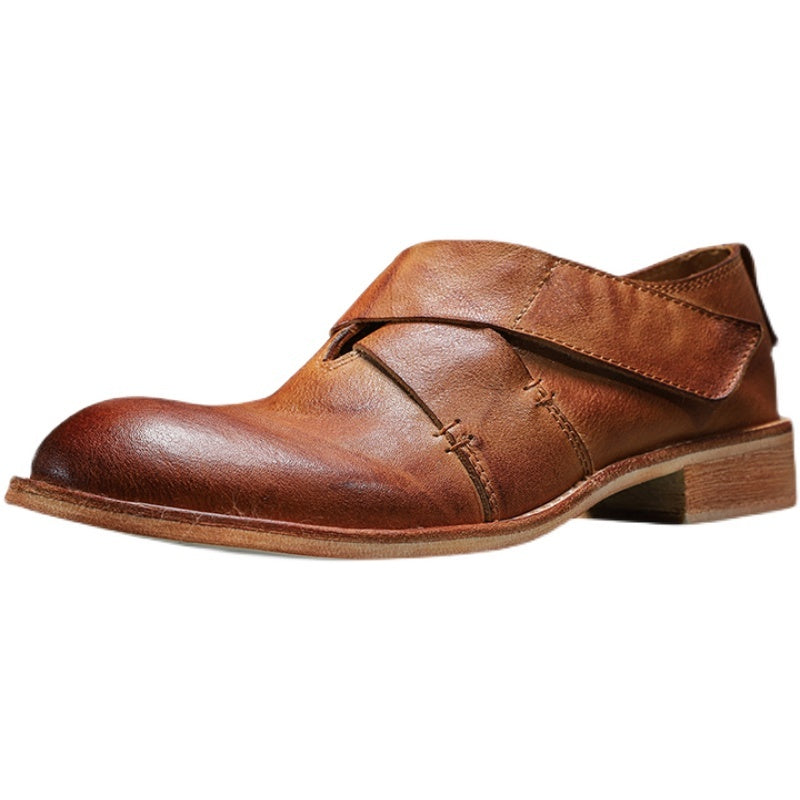 Brown leather shoe with strap closure on a white background