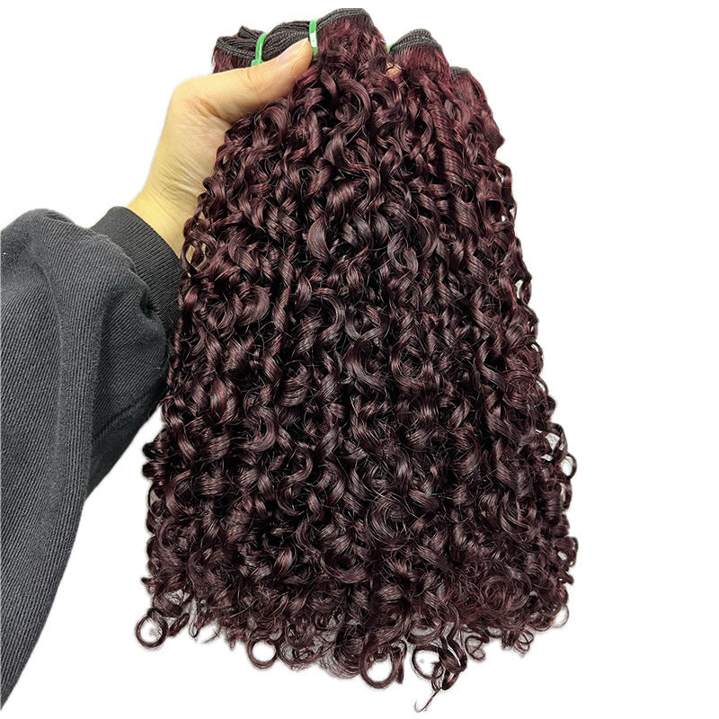 Curly hair extensions held by a person against a white background