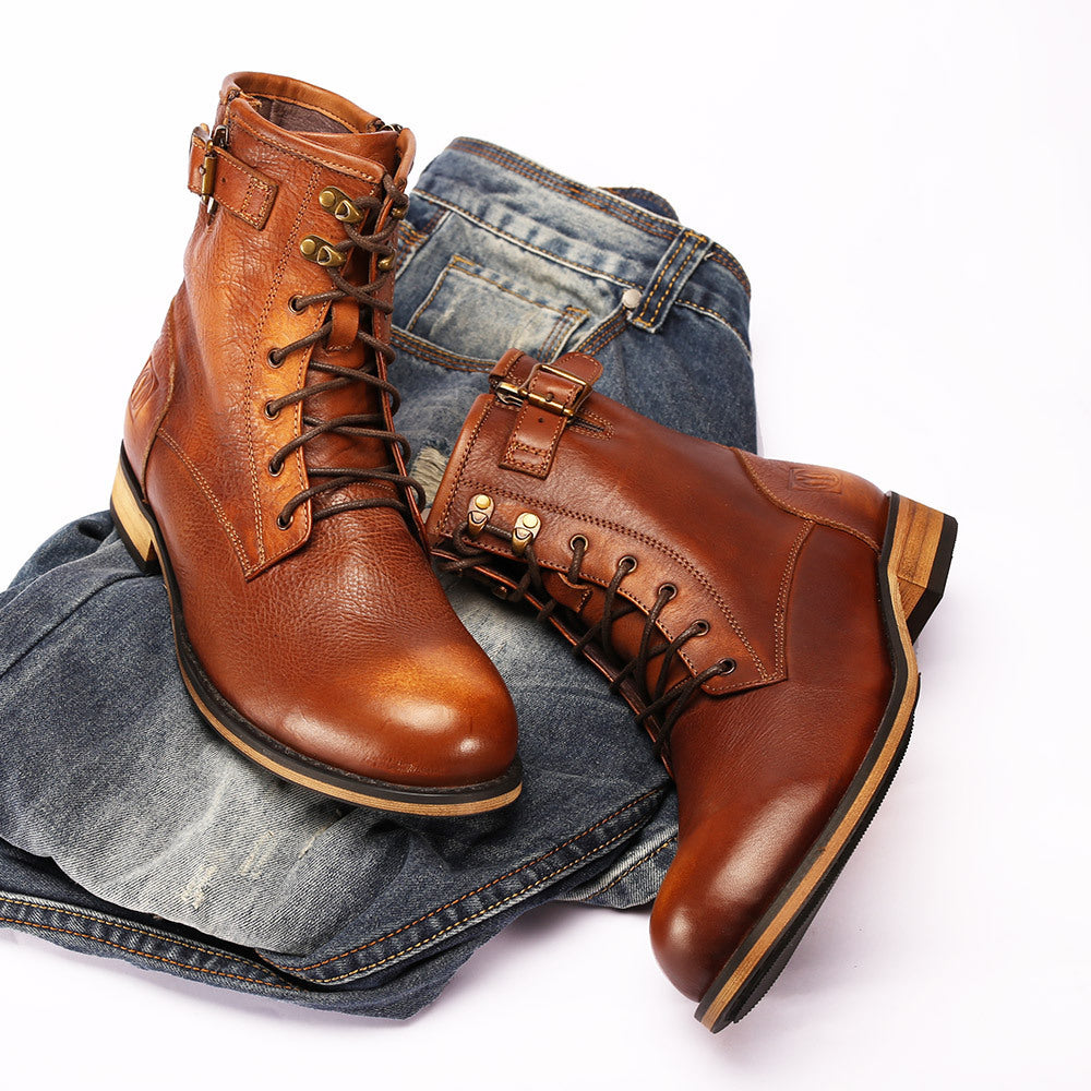 Brown leather boots on a white background with jeans underneath