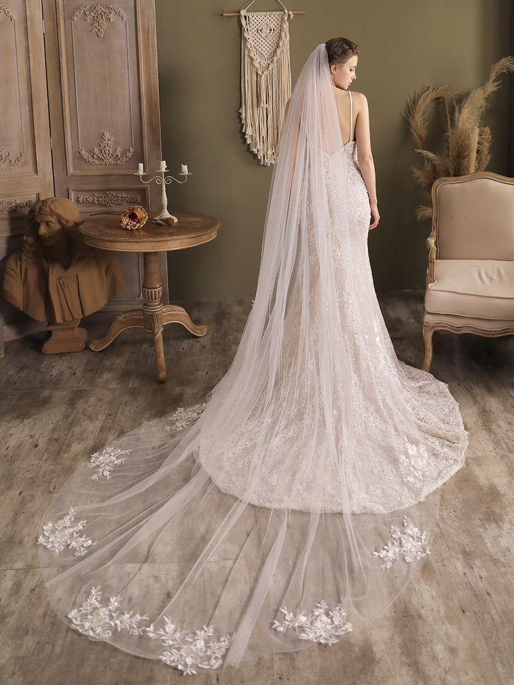 Bride in a wedding dress with a long veil in an elegant room.