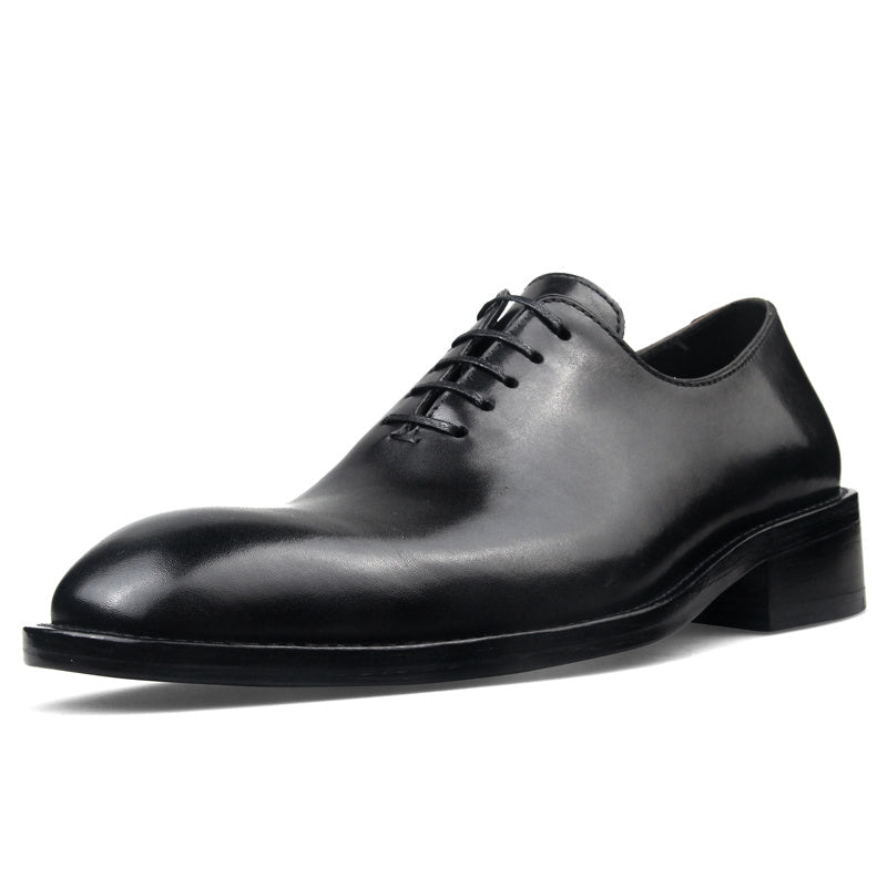 Black leather dress shoe on a white background