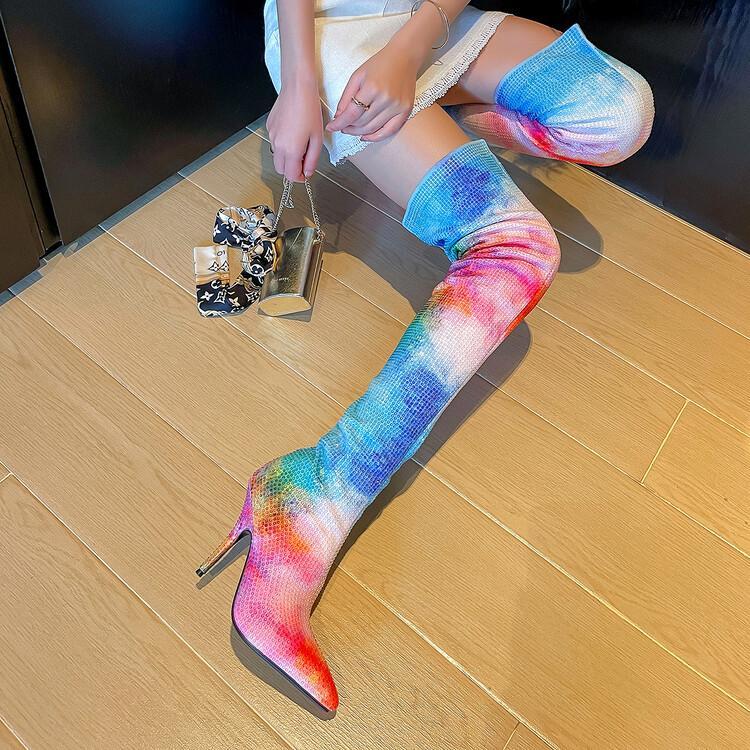 Person wearing colorful knee-high socks with high heels on a wooden floor.