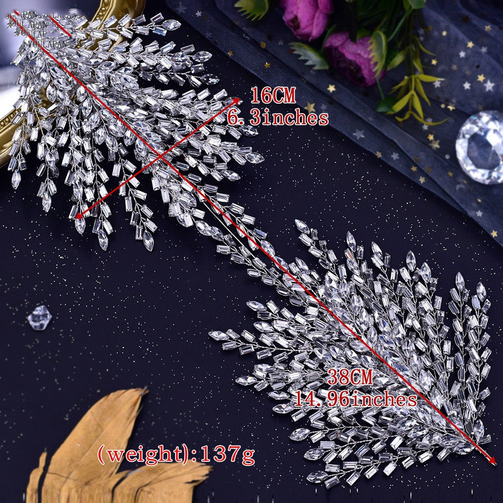 Decorative crystal leaf with measurements on a dark fabric background