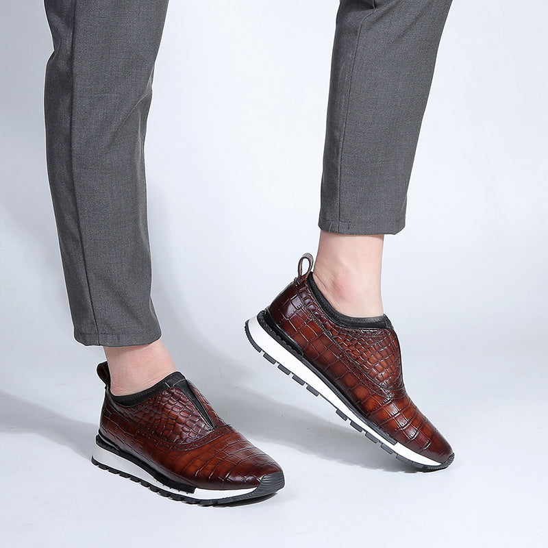 Brown crocodile-patterned shoes worn with gray pants on a light gray background