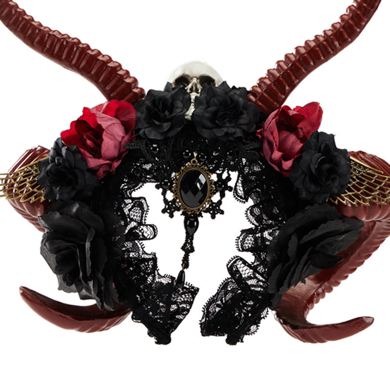 Decorative headpiece with red and black flowers, black lace, and brown horns on a white background