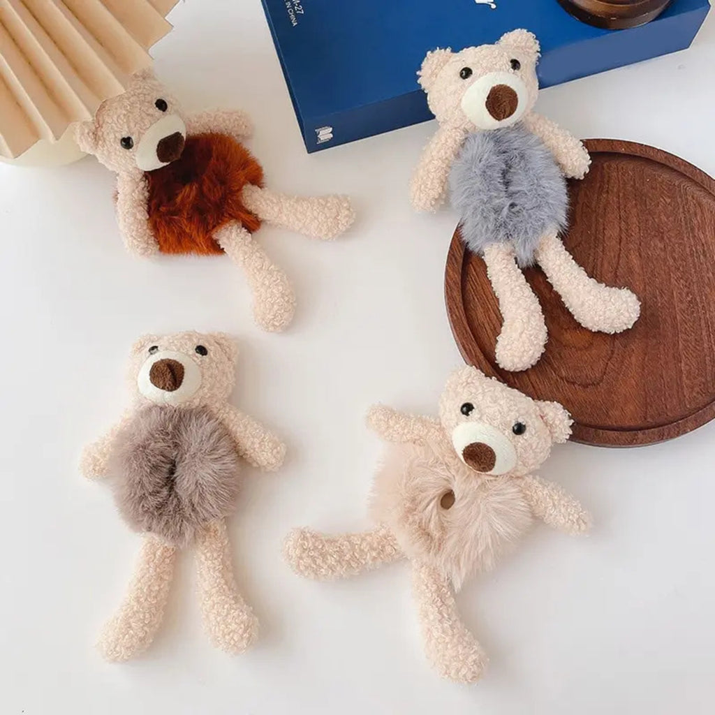 Four teddy bear toys with different colored fur on a white surface.